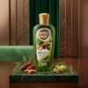 Golden Pearl Hello Hair 10 Natural Herbs Hair Oil 100ml green bottle with gold cap on a marble slab — Chaudhary Superstore