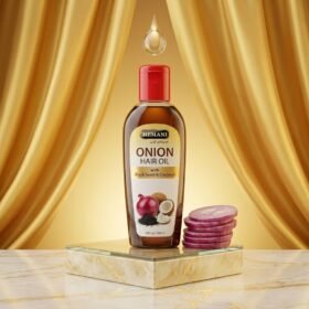 Hemani Onion Hair Oil With Black Seed & Coconut 100ml bottle on a marble podium — Chaudhary Superstore