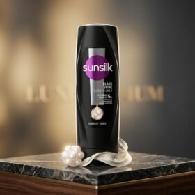 Sunsilk Black Shine Conditioner 180ml dark bottle displayed on a luxury marble surface with pearl accents by Chaudhary Superstore