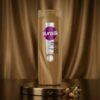 Sunsilk Hairfall Solution Shampoo 185ml golden-brown bottle displayed on a luxury dark marble surface with botanical props by Chaudhary Superstore